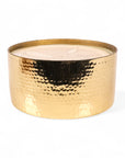 Gold candle holder with a white candle inside on a white background