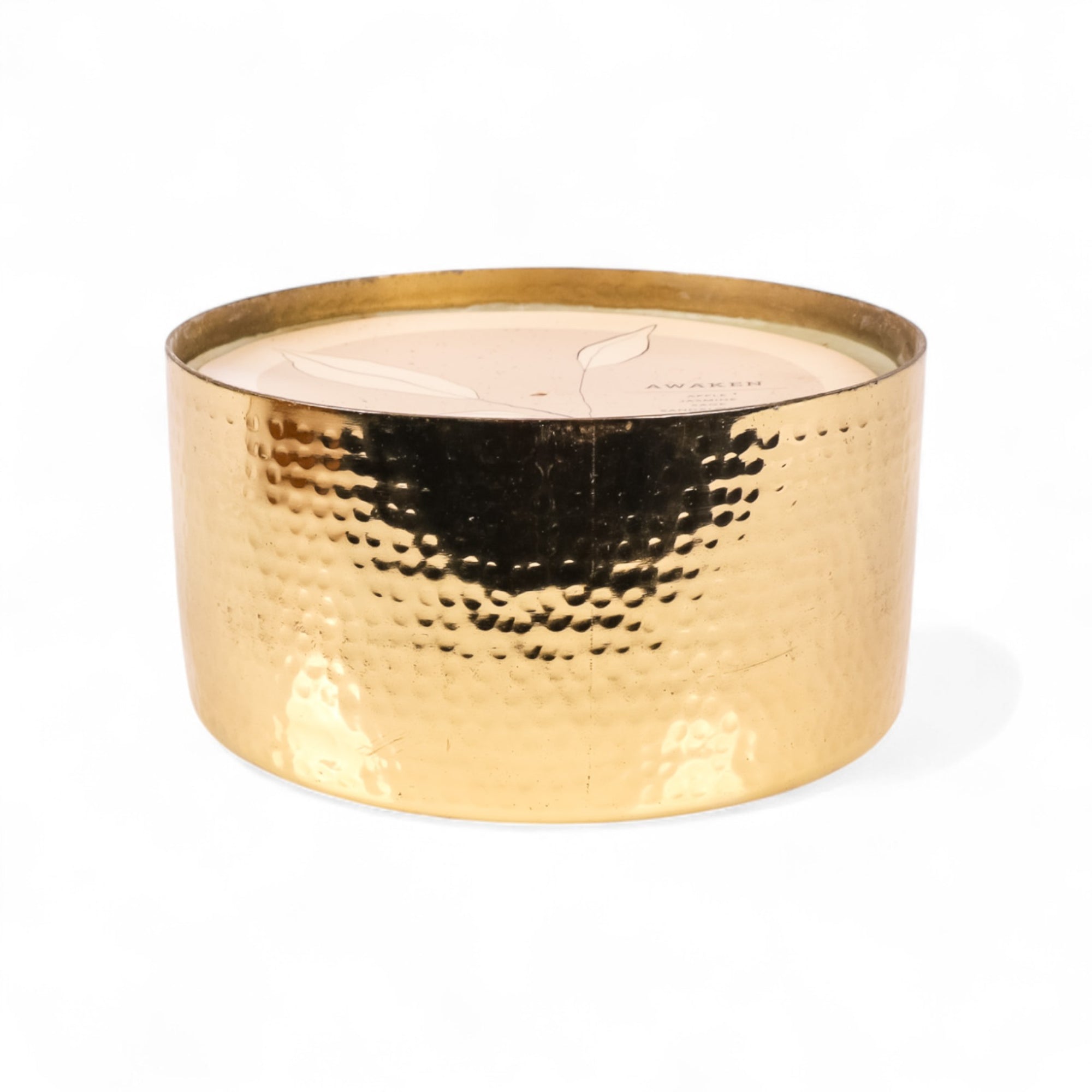Gold candle holder with a white candle inside on a white background