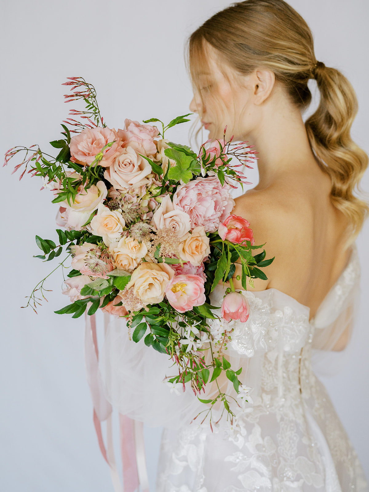 Bride with the Blush A la Carte Wedding Bridal Boquet from Green Fresh Florals + Plants over her shoulder
